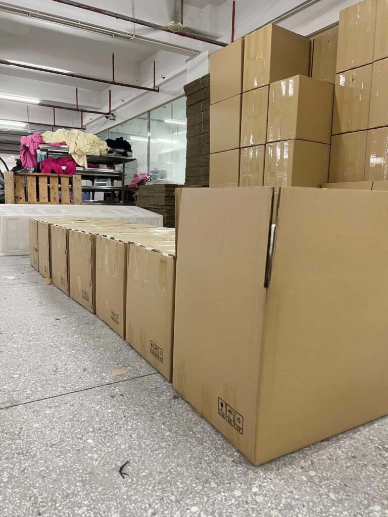 Stacked export cartons in garment factory warehouse ready for international shipping