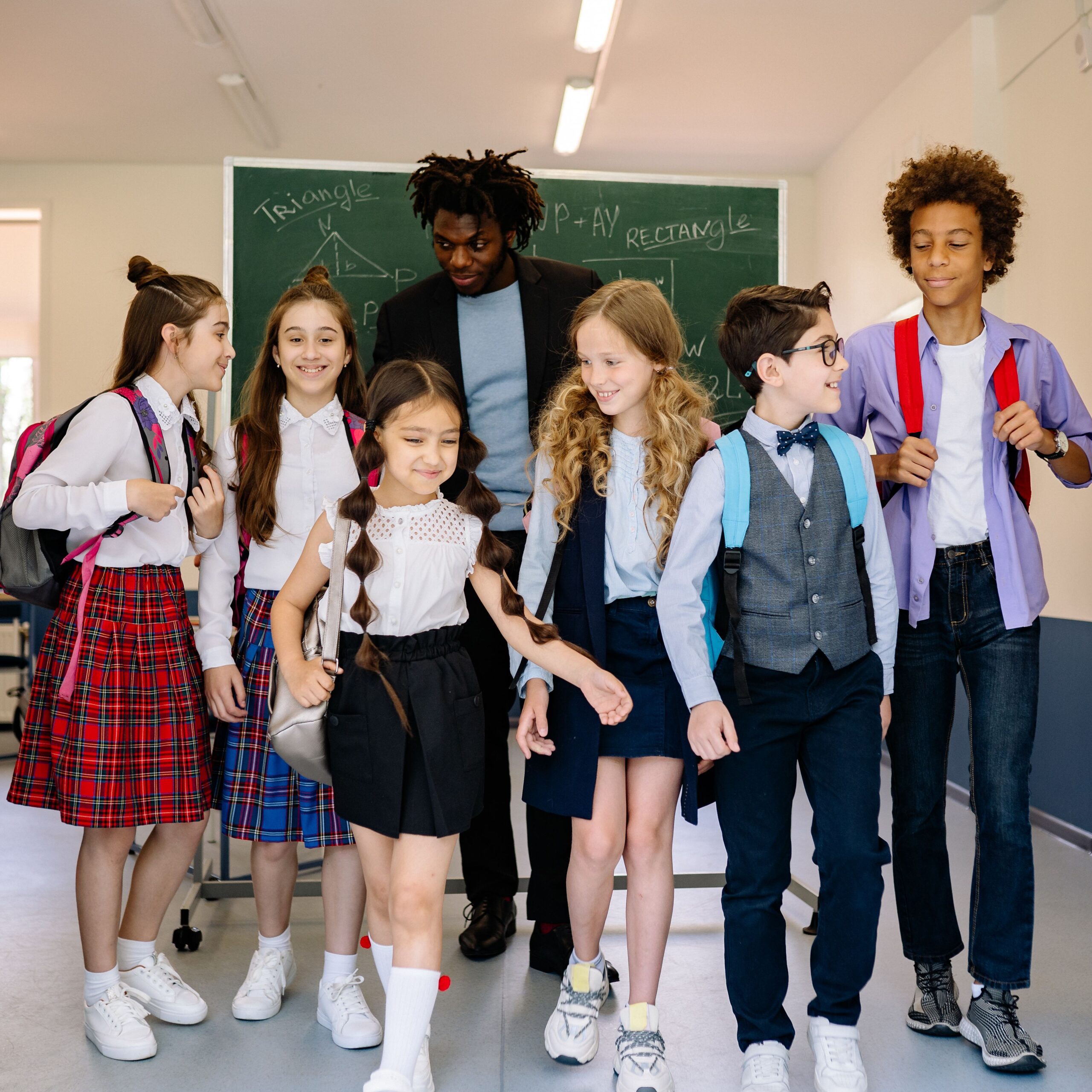 Schoolchildren with teacher in classroom, custom wholesale t-shirts for school uniforms and educational events