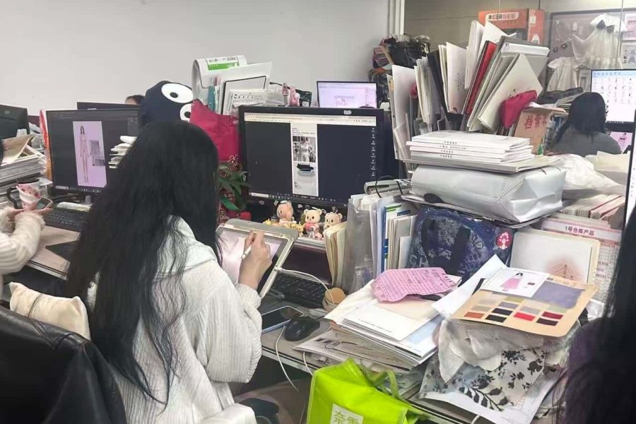 Fashion designer working on CAD software and tablet for garment pattern development